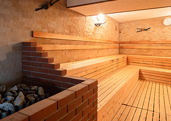1F大浴場「高温(ドライ)サウナ」／設定温度80度。木目調の落ち着いた空間で''ととのう''ひと時を